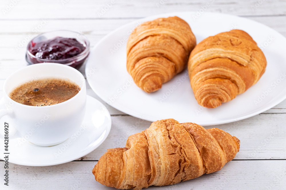 croissants and a cup of coffee on a wooden background. Breakfast