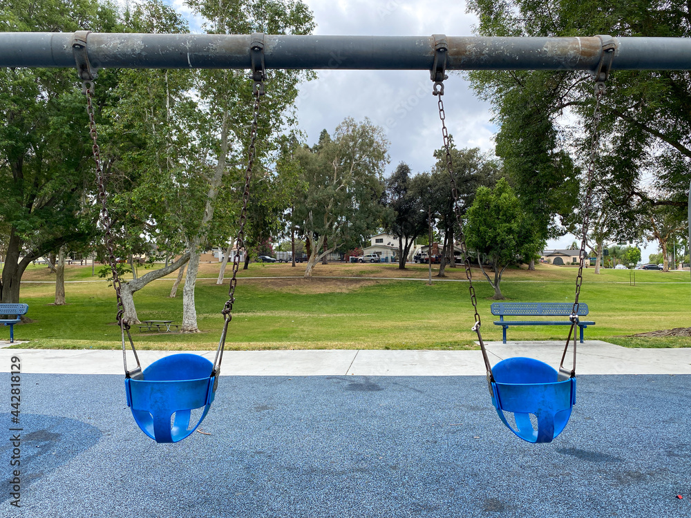 Swings at children playground activities in public park. swing on modern playground. Urban neighborhood childhood concept. 