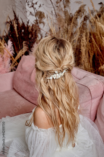 The bride's hair, hairdressing. Blonde with curly hair.