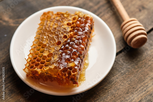 Honeycomb close-up. Fresh honey from the field and honey stick on an old wooden table.