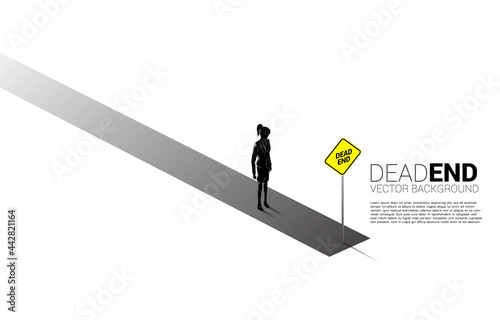 Silhouette businesswoman standing with dead end signage . Concept of wrong decision in business or end of career path.