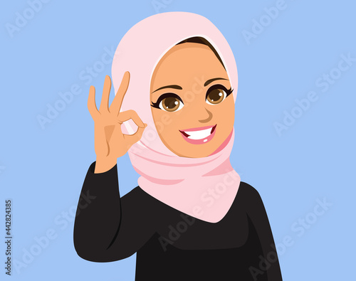 Beautiful young muslim arab woman with hijab making ok hand gesture