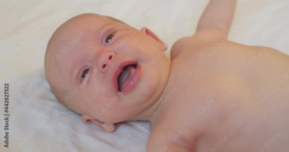 portrait of a modern child. cute baby crying in bed.view from above. portrait of a modern child. cute baby crying in bed.view from above.