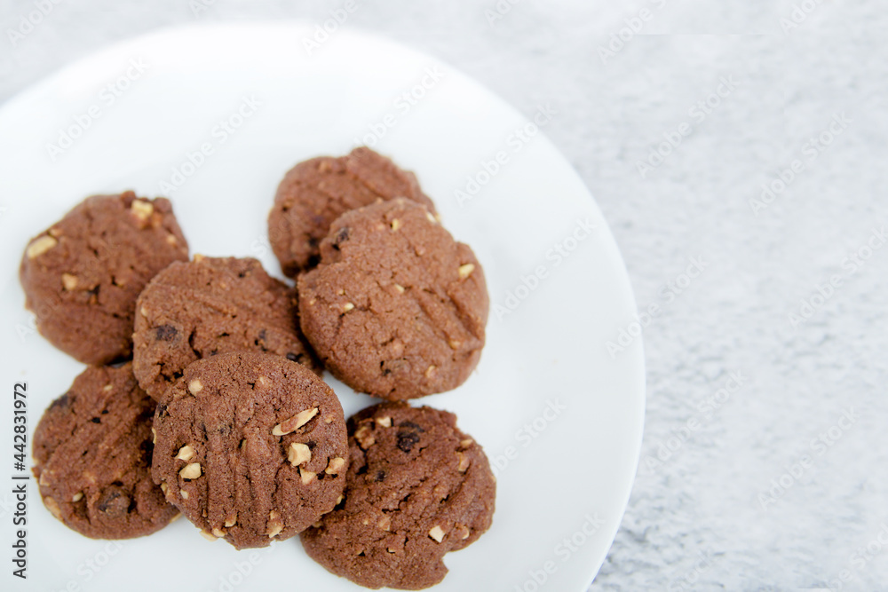 A vertical top view of delicious chocolate chips cookies on a white plate