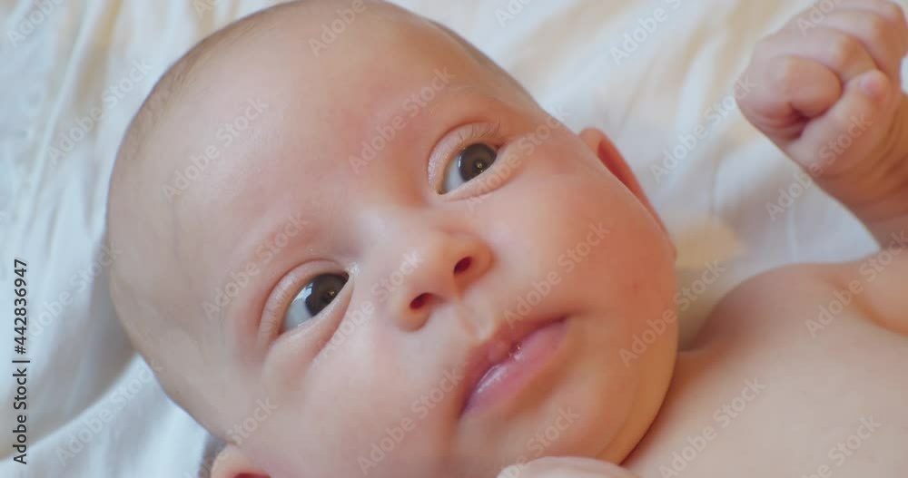cute funny baby with surprised look lies in bed. portrait. close-up. cute funny baby with surprised look lies in bed. portrait. close-up.