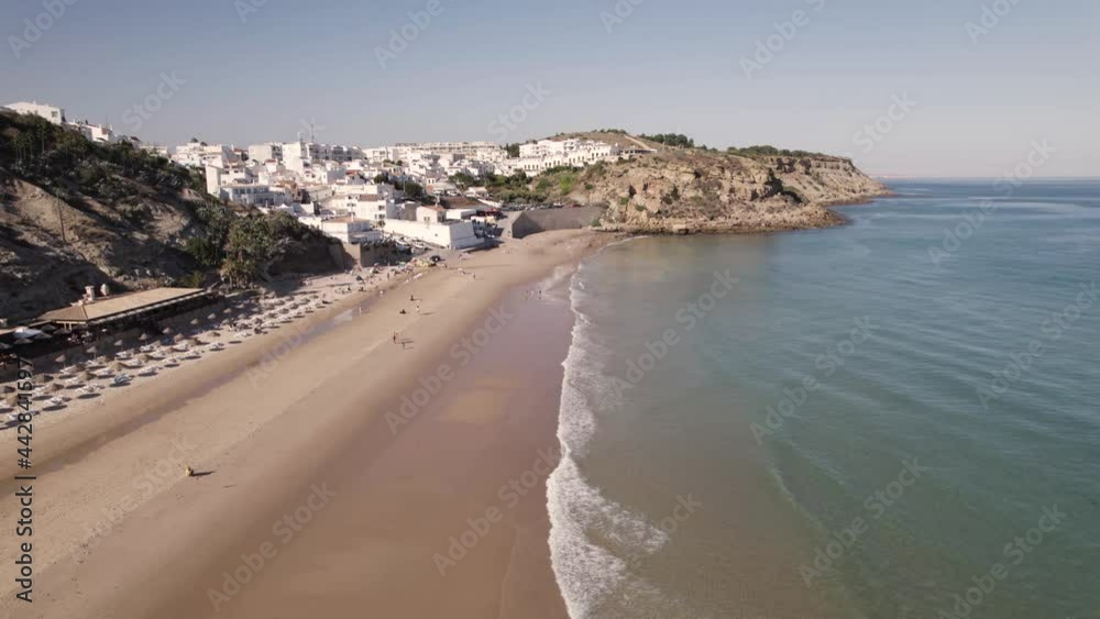 Breathtaking aerial view of Burgau Portugal splitting between aqua green ocean and whitewashed stucco buildings. Breathtaking aerial view of Burgau Portugal splitting between aqua green ocean and whitewashed stucco buildings.
