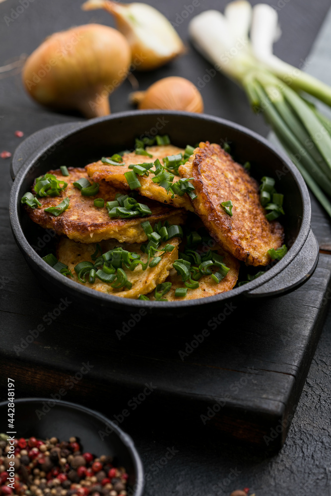 Fototapeta premium Delicious onion fritters with sour cream and green onion on plate, closeup