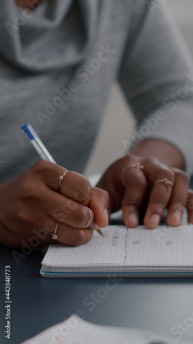 African american student writing high school homework on notebook working remote from home. Black woman studying math using elearning univeristy platform during online courses sitting at desk