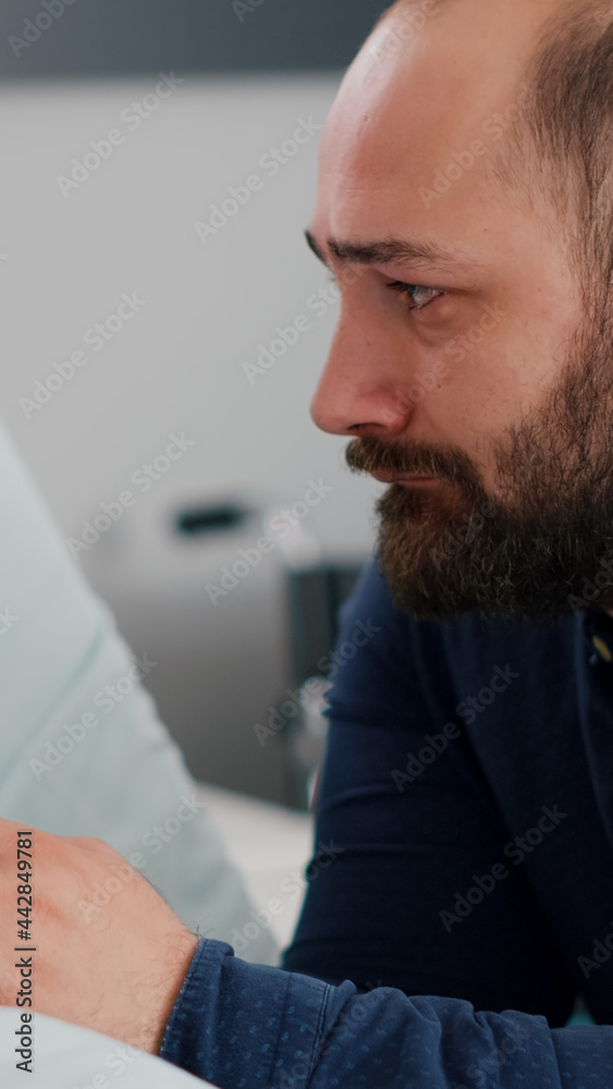 Fototapeta premium Worried emotional father crying beside sick daughter waiting for healthcare treatment during sickness recovery consultation in hospital ward. Child sleeping recovering after medical surgery