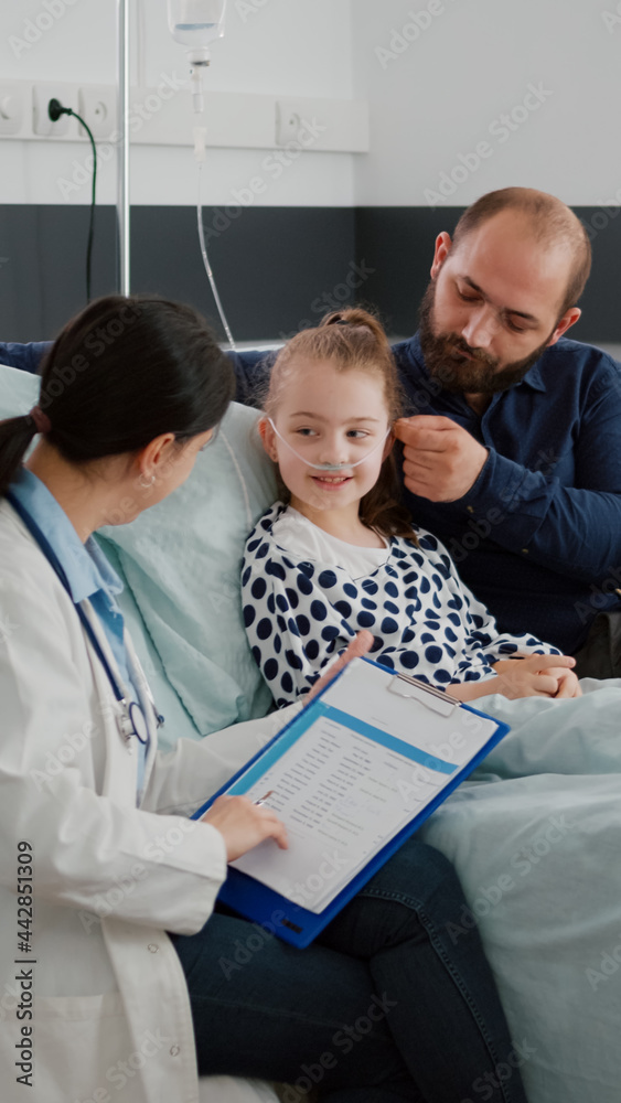 Fototapeta premium Physician woman doctor monitoring disease symptoms writing antibiotics treatment during recovery consultation in hospital ward. Hospitalized child with nasal tube recovering after breathing surgery