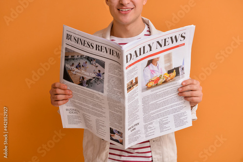 Young man reading newspaper...