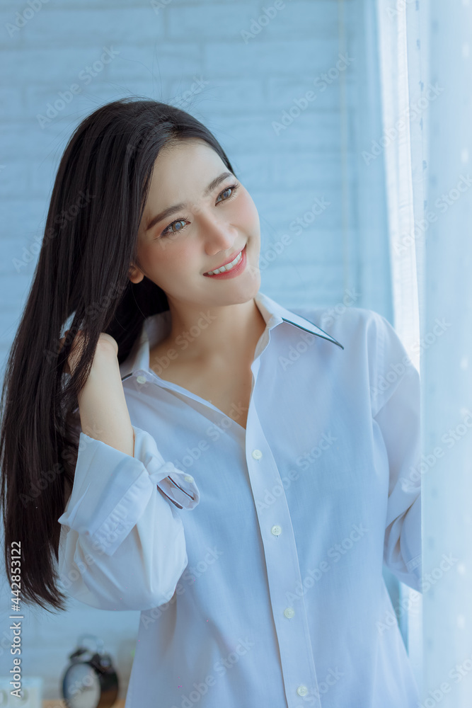 portrait of a business woman inwhite shirt stand near window portrait of a business woman inwhite shirt stand near window