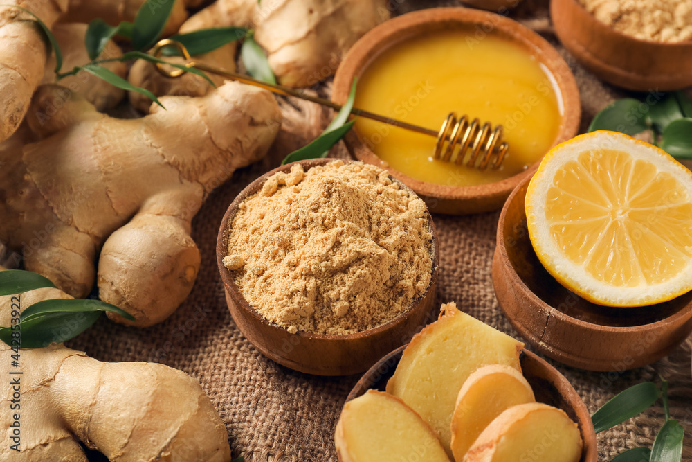 Fototapeta premium Bowl with ginger powder, honey and lemon on table, closeup