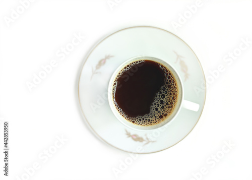 Black aromatic coffee with foam in an elegant porcelain coffee cup and saucer. White chinaware. White classic cup of hot coffee isolated on white background. Hot instant energetic drinks. Coffee break