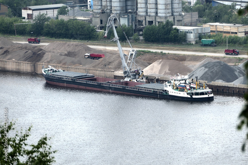 Fototapeta Barge on the river Unloading river sand from a barge Navigable river, river port