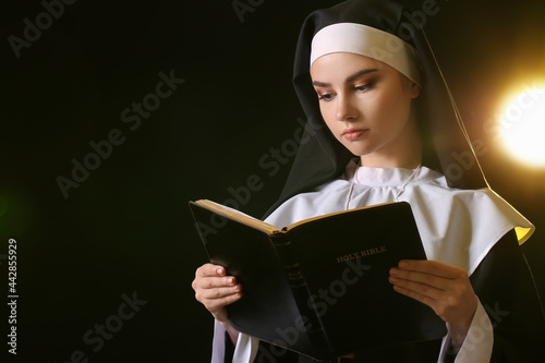Young nun with Bible on dar...