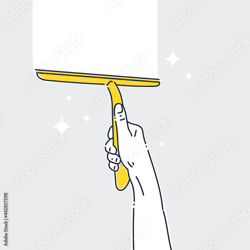 Image on the theme of cleaning and cleanliness. A mans hand is holding a window cleaning scraper.