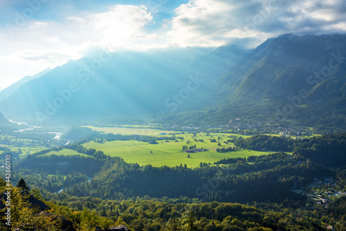 Valley against mountains. Sun rays