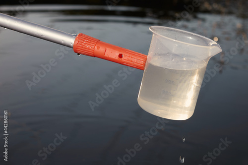 Detail of sampling beaker used for water samples collecting photo