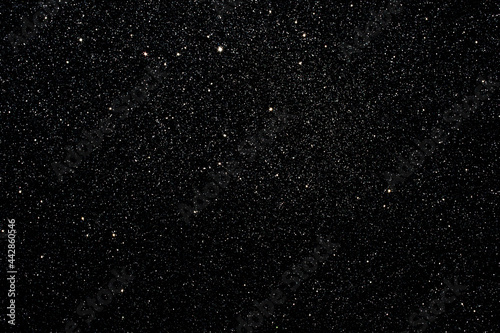 Black background glitter stars in beautiful style on dust. Luxury cosmic glitz effect. Night sky magic pattern