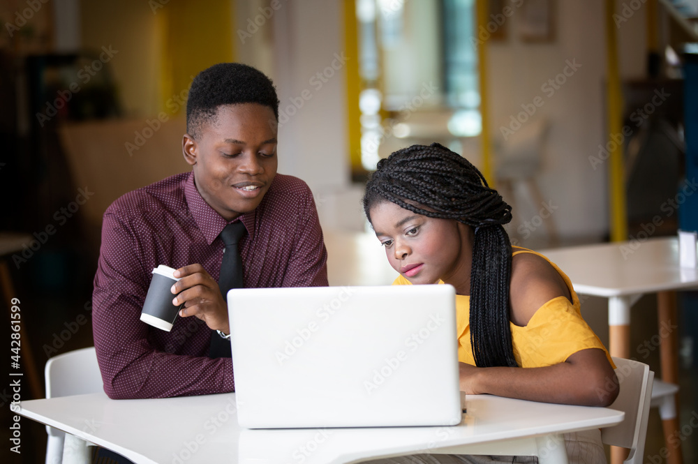 Portrait of a young African girl working at a laptop in a cafe during a coffee break. A break, relax Portrait of a young African girl working at a laptop in a cafe during a coffee break. A break, relax
