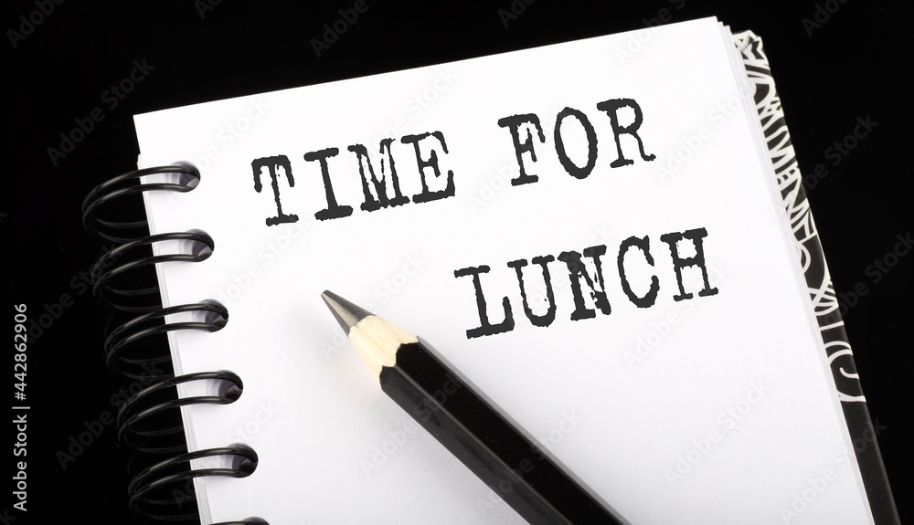TIME FOR LUNCH written text in small notebook on black background