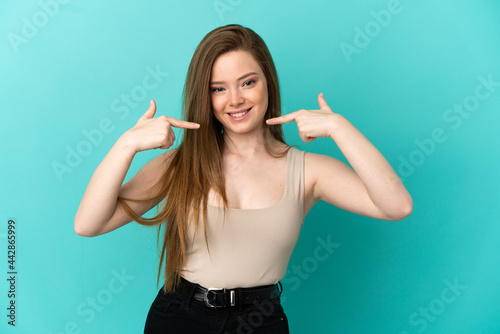 Teenager girl over isolated blue background giving a thumbs up gesture
