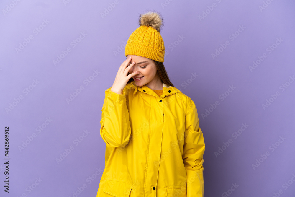 Teenager girl wearing a rainproof coat over isolated purple background laughing Teenager girl wearing a rainproof coat over isolated purple background laughing