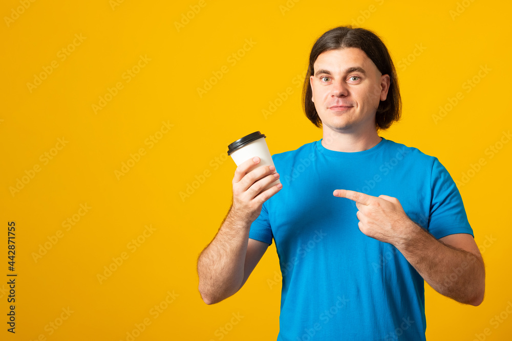 Portrait of young handsome caucasian man in blue shirt over yellow background holding cup of coffee to go. Banner copy space. Portrait of young handsome caucasian man in blue shirt over yellow background holding cup of coffee to go. Banner copy space.