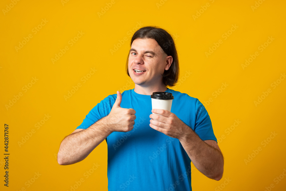 Man holding coffee to go cup showing thumb up. Coffee take away cup in hands. Man holding coffee to go cup showing thumb up. Coffee take away cup in hands.