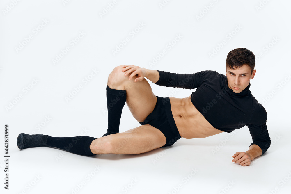 a guy with a pumped-up torso in a sweater shorts and socks lies on the floor a guy with a pumped-up torso in a sweater shorts and socks lies on the floor