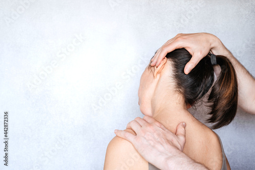 A chiropractor performing a manipulation on woman's neck and administering of spinal adjustments to relive neck pain