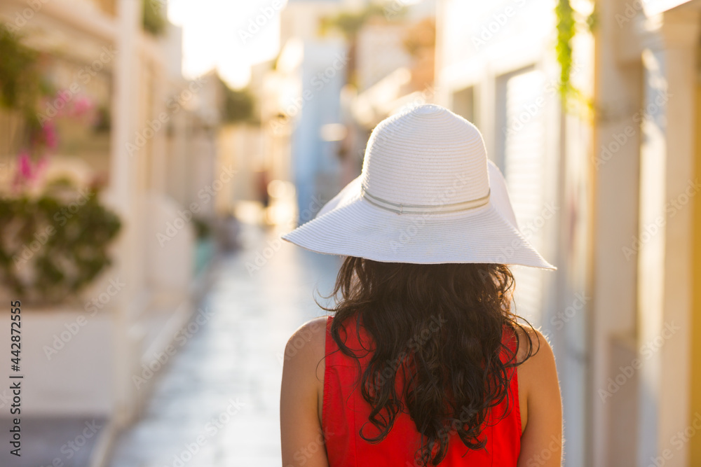 Santorini travel tourist brunette woman in red dress visiting famous white Oia village. Greece, Europe. Santorini travel tourist brunette woman in red dress visiting famous white Oia village. Greece, Europe.