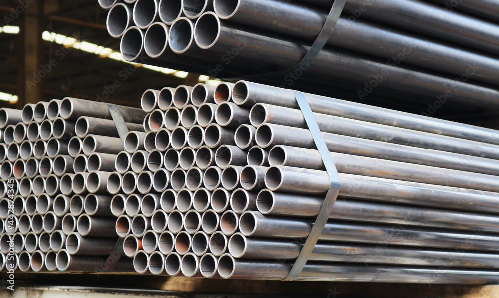 Round carbon steel pipe packaging in warehouse for logistics. - obrazy, fototapety, plakaty 