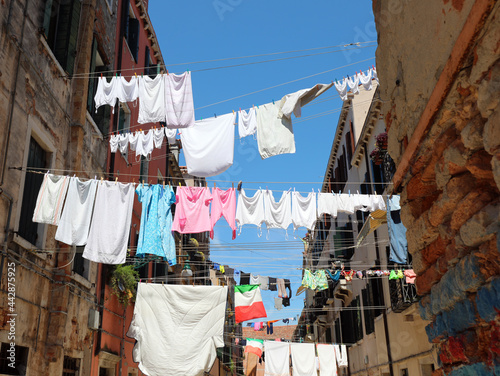 clothes hanging out drying in the sun in the narrow street of the typical Italian city photo