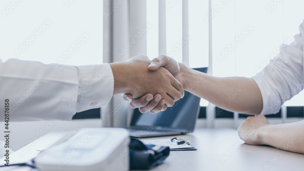 Doctor shake hands to congratulate the patient who came to treat the sick and recovered normally, Congratulations between doctor and patient, Medical treatment and health check.