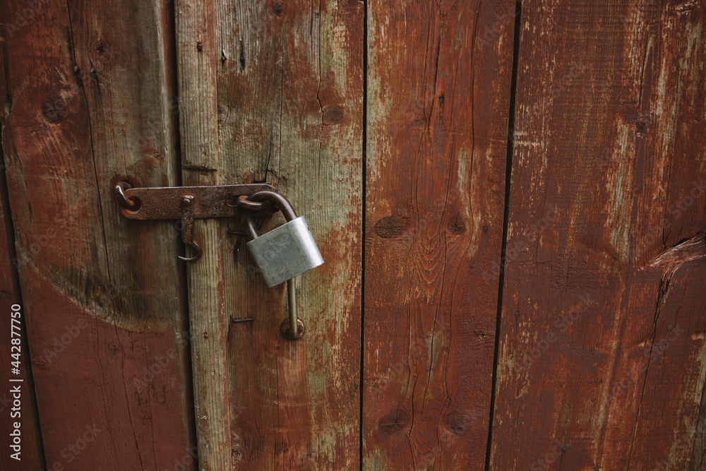 Metal padlock on old wooden gate, rustic rural wallpaper, wood texture on old door Metal padlock on old wooden gate, rustic rural wallpaper, wood texture on old door