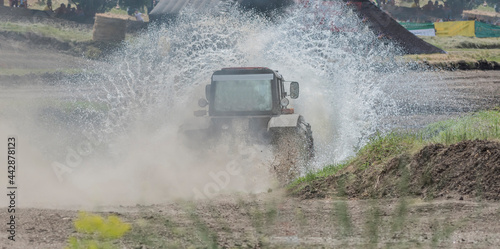 Farm tractor overcomes a water barrier