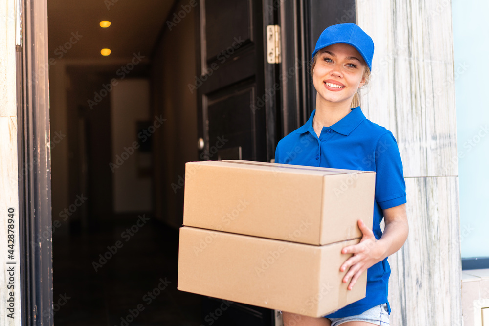 Young delivery woman at outdoors holding boxes with happy expression Young delivery woman at outdoors holding boxes with happy expression