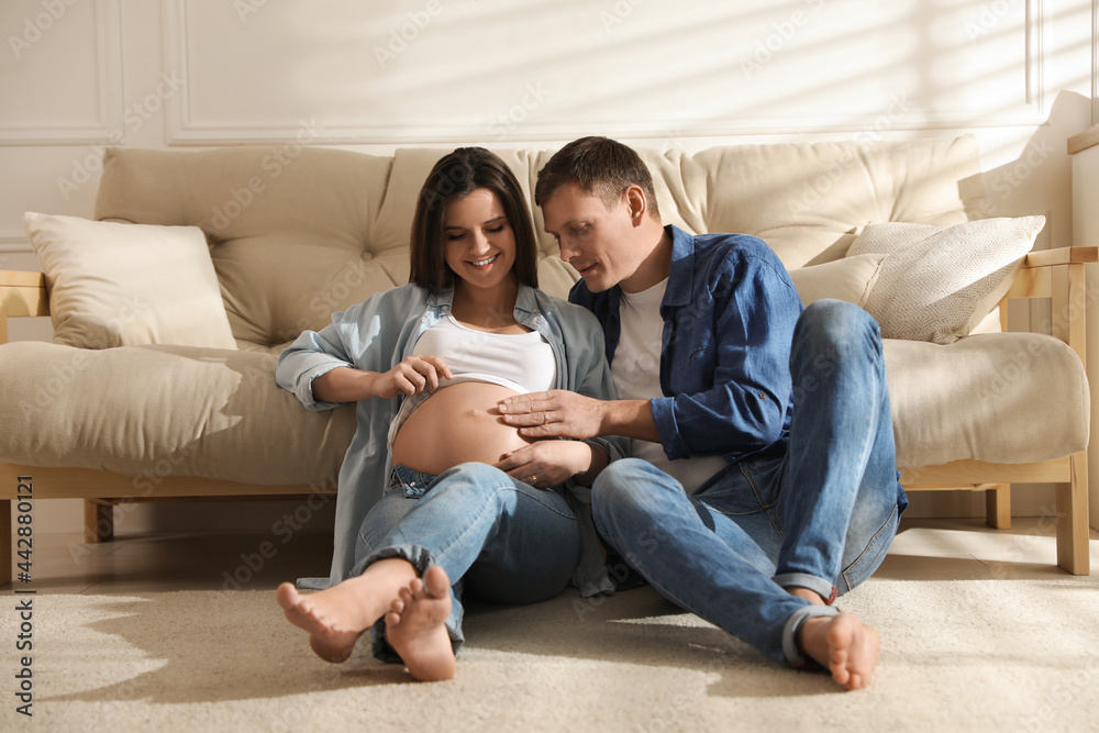 Young pregnant woman with her husband at home