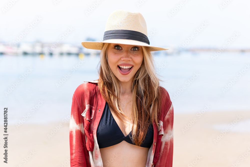 Young pretty woman in summer holidays at beach with surprise facial expression