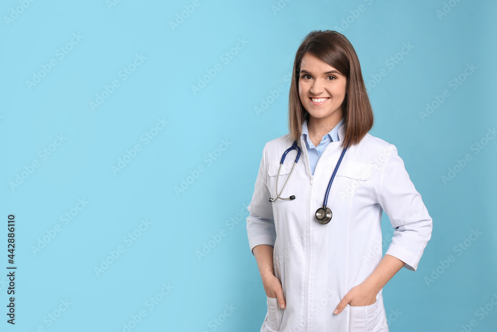 Pediatrician with stethoscope on light blue background, space for text Pediatrician with stethoscope on light blue background, space for text