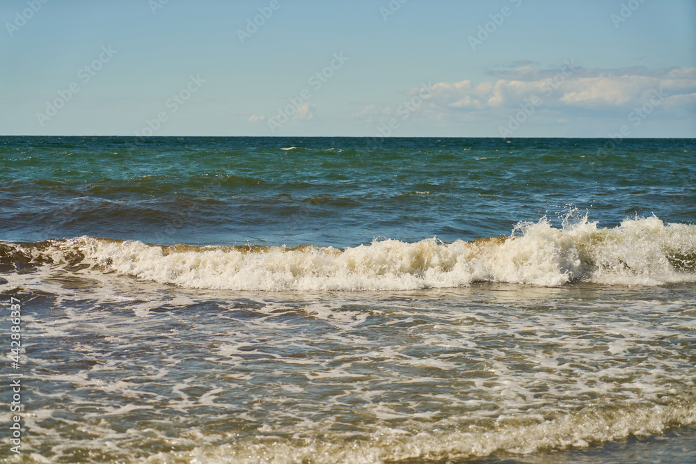 Welle im Meer vor einem blauen Himmel in Ostsee Welle im Meer vor einem blauen Himmel in Ostsee