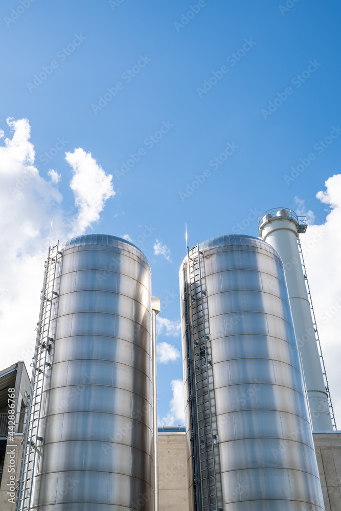 Two stainless steel silos in a factory