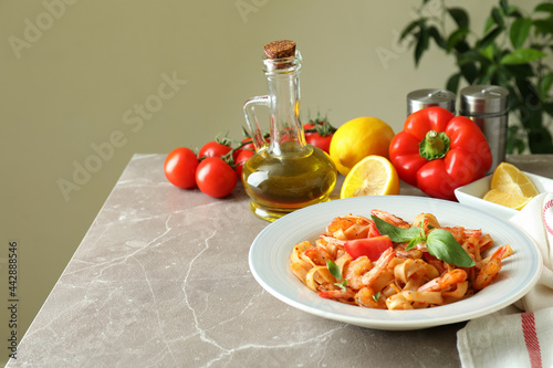 Concept of cooking shrimp pasta on gray textured table photo