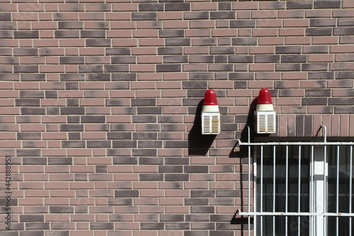 Eine Alarmanlage an einer Hauswand mit einem vergitterten Fenster, Sicherheit photo