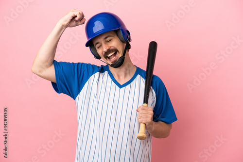 Photography Young caucasian man playing baseball isolated on pink background celebrating a v