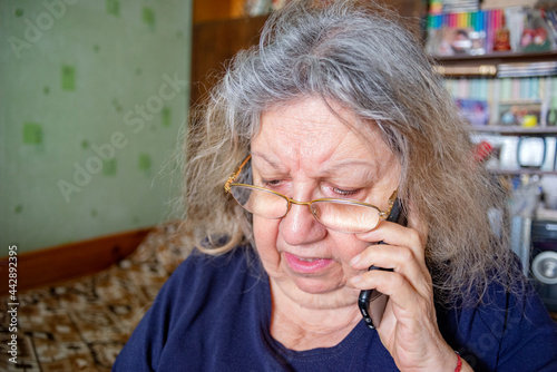 Serious Elderly Jewish Woman Talking on the Phone at Home