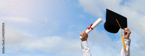 Education. happy students in gowns are celebrating graduation Throwing hands up a certificate and Cap in the air, Graduation day concept. Graduation day on sky banner background.