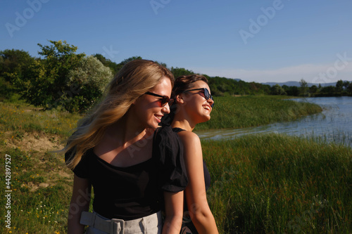 young beautiful women laughing standing by the lake